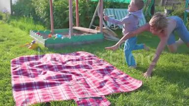 两个孩子在<strong>炎热</strong>的<strong>夏天</strong>在草坪上玩耍。 孩子们笑着，他们跑着落在草坪上。 户外娱乐